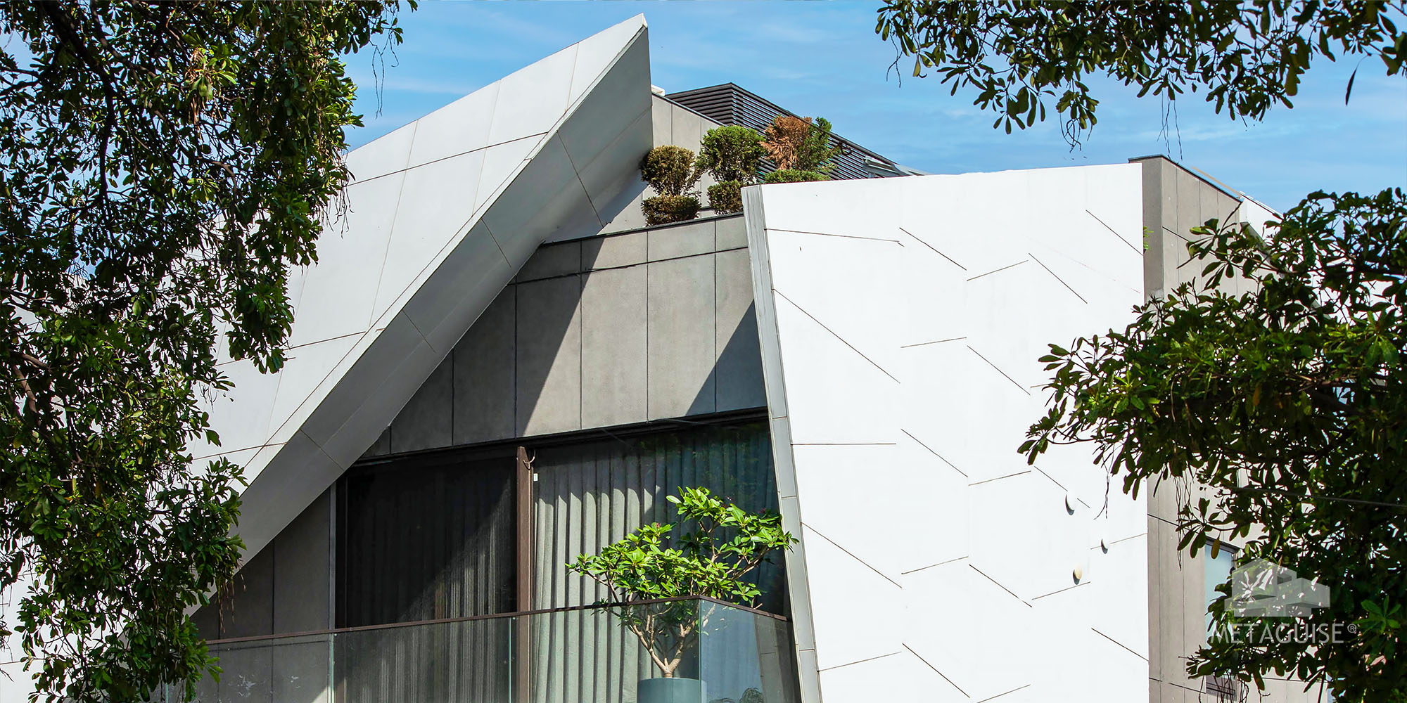 Angular folded white metal panels on a residence with a landscaped terrace