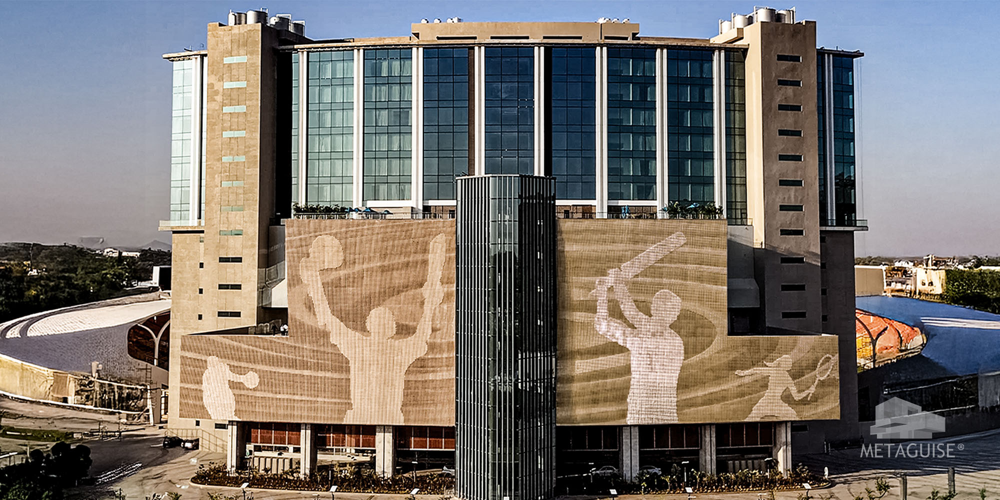 Miraj Stadium Rajasthan facade with cricketer silhouettes rendered in gold toned metal across a large building elevation