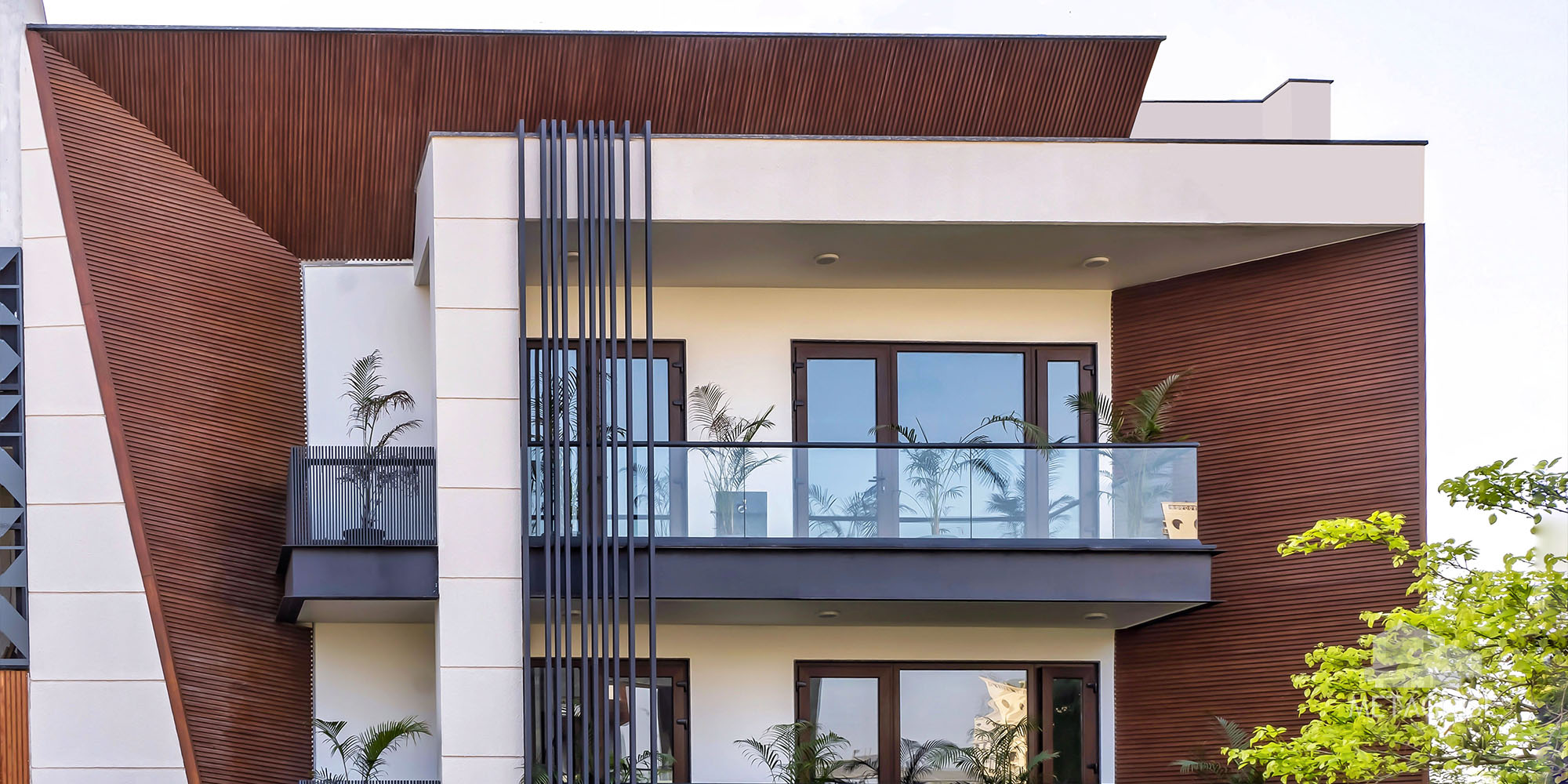 Residence with timber-look cladding and vertical dark metal fins beside a balcony