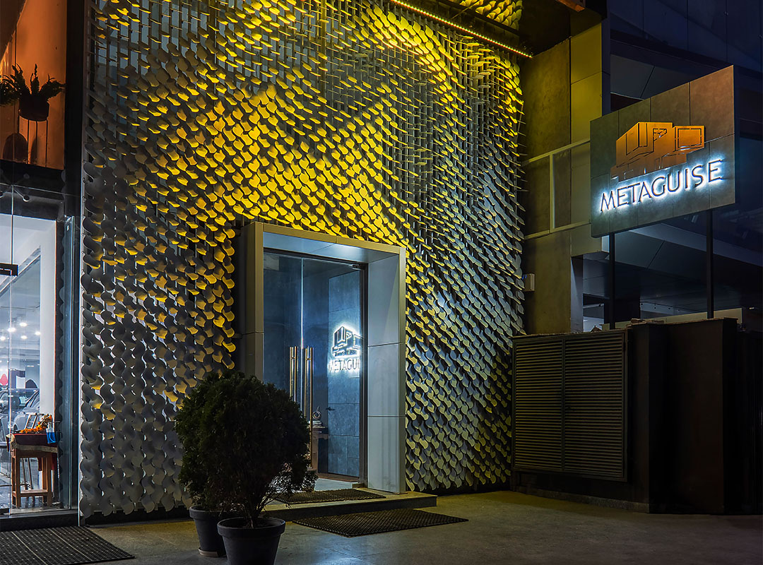 An image of the facade of Metaland featuring the white MetaSequin panels forming the tree of knowledge pattern 